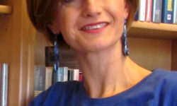 Zdjęcie przedstawia kobietę w niebieskich kolczykach