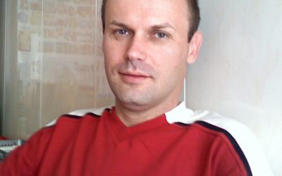 Zdjęcie przedstawia mężczyznę w czerwonej bluzce