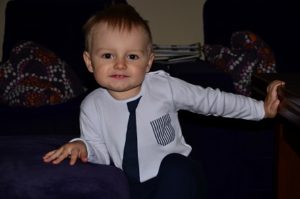 Zdjęcie przedstawia chłopczyka bluzce z wydrukowanym krawatem