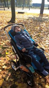 Zdjęcie przedstawia chłopaka na wózku w parku