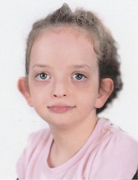 Zdjęcie przedstawia dziewczynkę uśmiechniętą