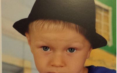 Zdjęcie chłopczyka z czarnym kapeluszem na głowie