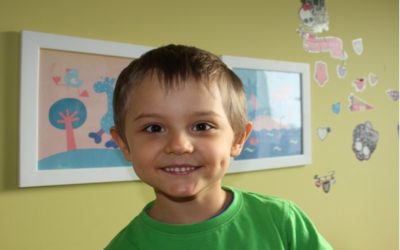 Zdjęcie przedstawia chłopczyka w zielonej bluzce