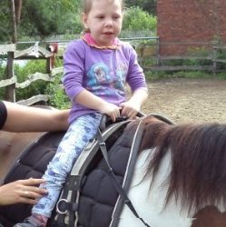 zdjęcie przedstawia dziewczynkę na koniu