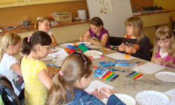 Zdjęcie przedstawia siedem dziewczynek przy stole