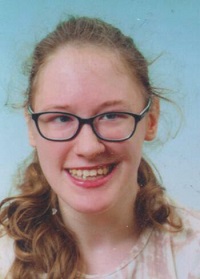 Zdjęcie przedstawia kobietę uśmiechniętą w okularach