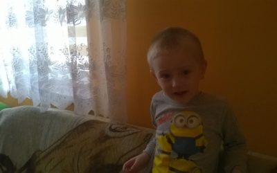 Zdjęcie przedstawia chłopczyka w szarej bluzce w minionki