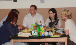 Zdjęcie przedstawia pięć osób przy stole