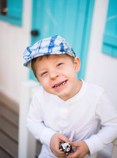 Zdjęcie przedstawia chłopczyka w czapce w kratę