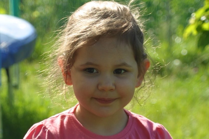 zdjęcie przedstawia dziewczynkę uśmiechniętą