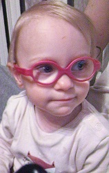 Zdjęcie przedstawia dziewczynkę w okularach