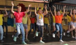 Zdjęcie przedstawia dzieci tańczące na scenie