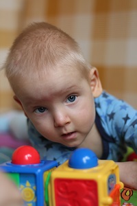 Zdjęcie przedstawia chłopca z zabawką