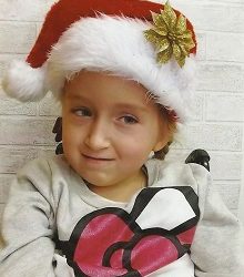 Zdjęcie przedstawia dziewczynkę w czapce Mikołaja