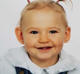 Zdjęcie przedstawia dziewczynkę uśmiechniętą