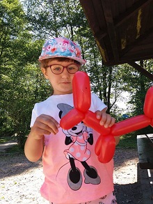 Zdjęcie przedstawia dziewczynkę z balonem