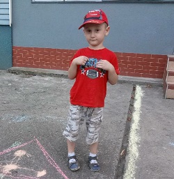 Zdjęcie przedstawia chłopca z czerwoną koszulką