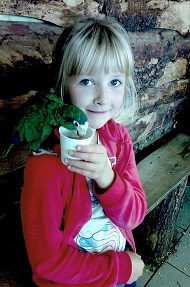 Zdjęcie przedstawia dziewczynkę uśmiechniętą z papugą
