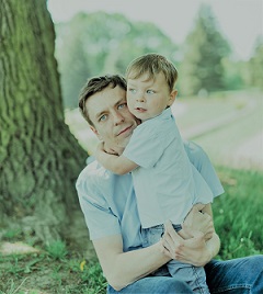 Zdjęcie przedstawia mężczyznę z dzieckiem