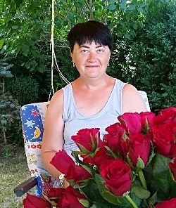 Zdjęcie przedstawia kobietę uśmiechnięta z różami