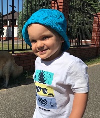 Zdjęcie przedstawia chłopca w czapce niebieskiej
