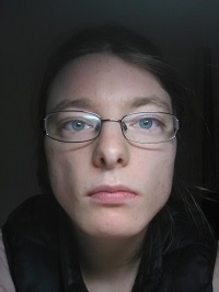 Zdjęcie przedstawia kobietę w okularach