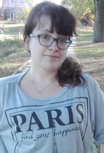 Zdjęcie przedstawia kobietę w okularach i w szarej bluzce