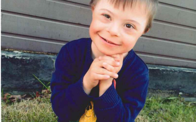 Zdjęcie przedstawia chłopca z uśmiechem na twarzy