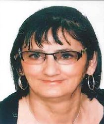 Zdjęcie przedstawia kobietę w okularach z kolczykami