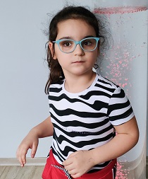 Zdjęcie przedstawia dziewczynkę w koszulce w paski z okularami