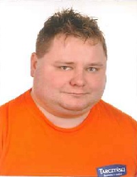 Zdjęcie przedstawia mężczyznę w pomarańczowej koszulce