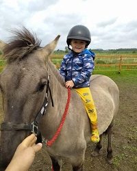 Zdjęcie przedstawia chłopca na koniu