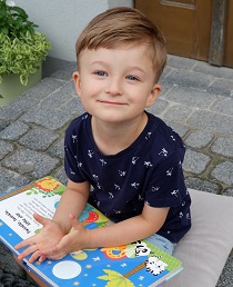 Zdjęcie przedstawia chłopca z książką