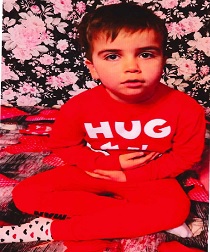 Zdjęcie przedstawia chłopca w czerwonym dresie