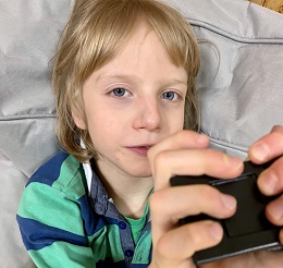 Zdjęcie przedstawia chłopca z zabawka w ręku