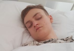 Zdjęcie przedstawia mężczyznę śpiącego w łóżku