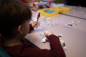 Zdjęcie przedstawia chłopca układającego puzzle