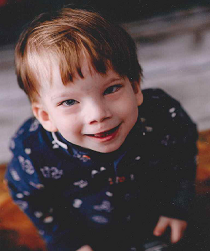 Zdjęcie przedstawia uśmiechniętego chłopca