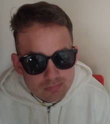 Zdjęcie przedstawia mężczyznę w okularach słonecznych