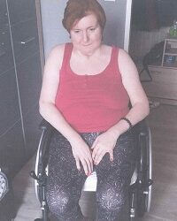 Zdjęcie przedstawia kobietę siedzącą na wózku