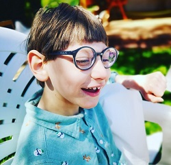 Zdjęcie przedstawia chłopa w zielonej koszuli i w okularach