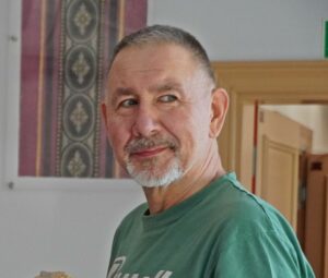 Zdjęcie przedstawia mężczyznę w zielonej koszulce