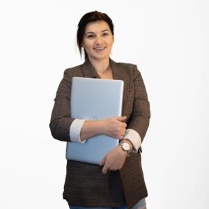 Zdjęcie przedstawia kobietę z laptopem w rękach